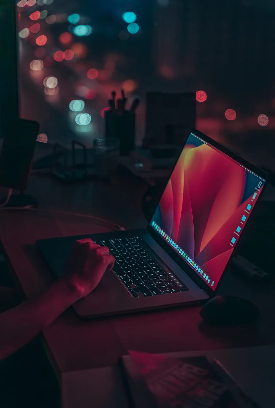 Ordinateur portable ouvert la nuit, lumières floues de la ville